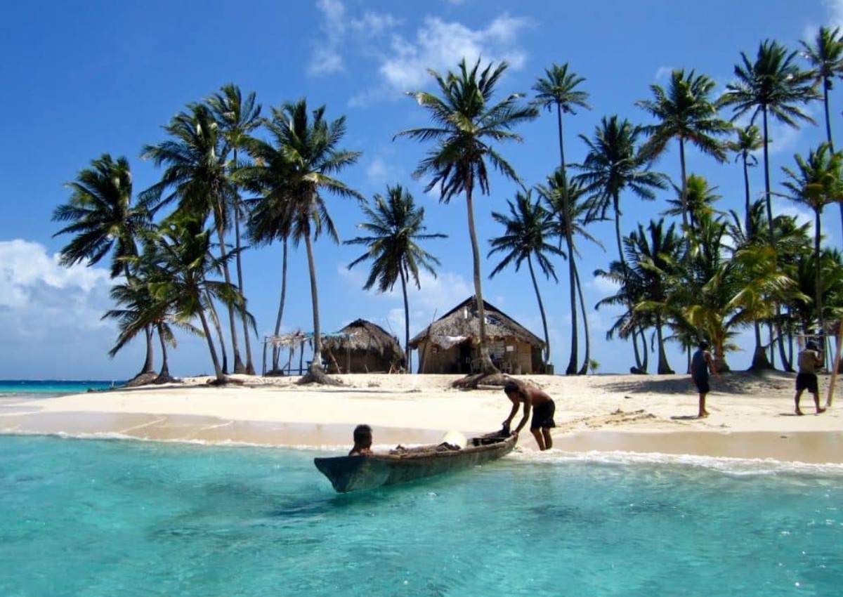 san-blas-helicopter-tour-002 A canoe resting on a beach in San Blas, Panama.